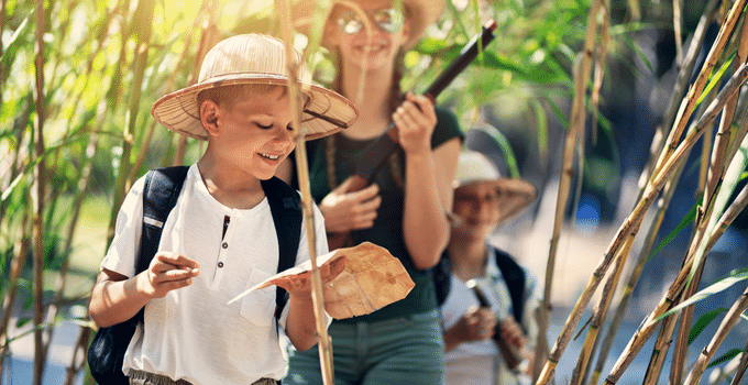 Kind mit Schatzkarte im Wald bei der Schnitzeljagd